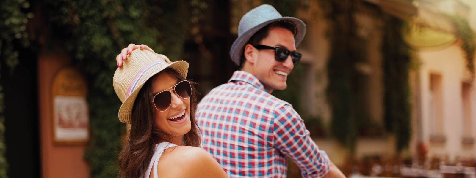 Una pareja en verano con sombreros de paja en bicicleta