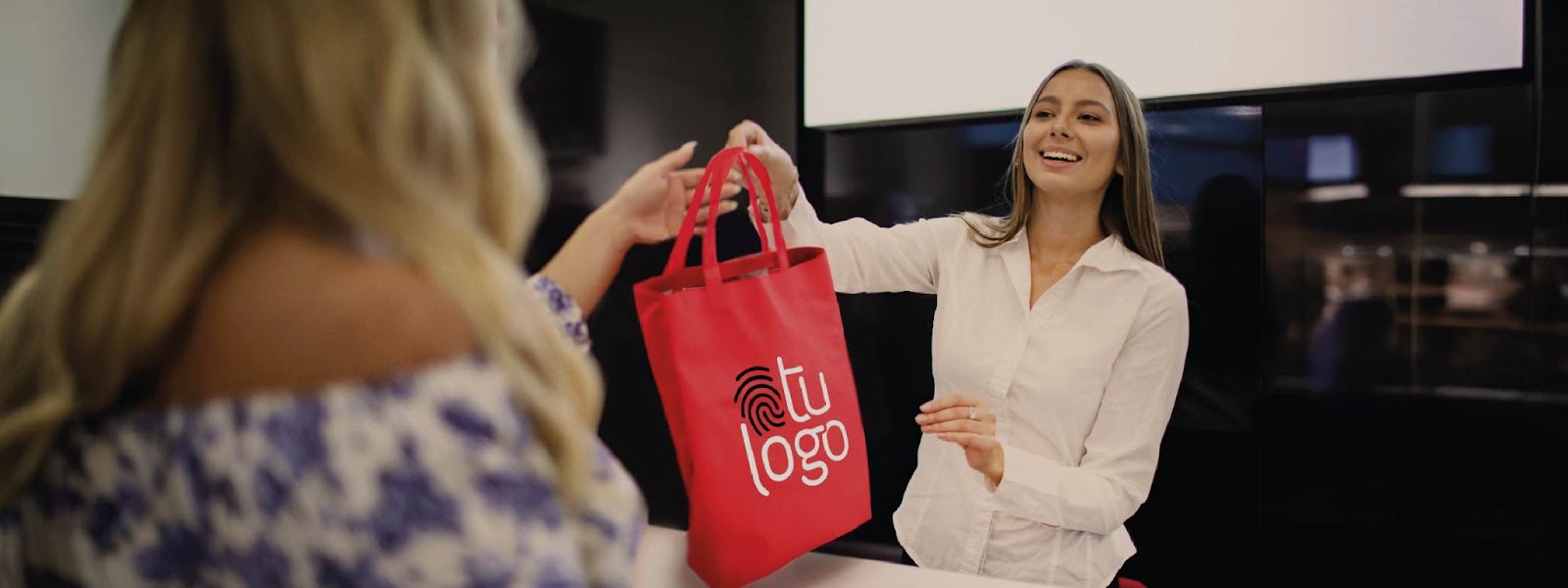 Entregando una bolsa personalizada con Tu Logo en un evento empresarial