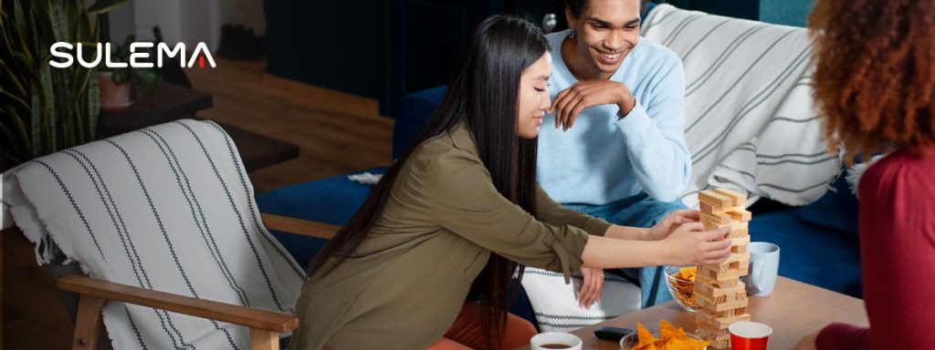 amigos jugando el juego de mesa Yenga, mientras comparten unos snacks