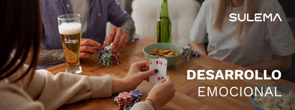 texto que se lee: "Desarrollo emocional" debido a compartir juegos de mesa entre amigos. Se ve a unos amigos jugando al póker mientras beben unas cervezas.