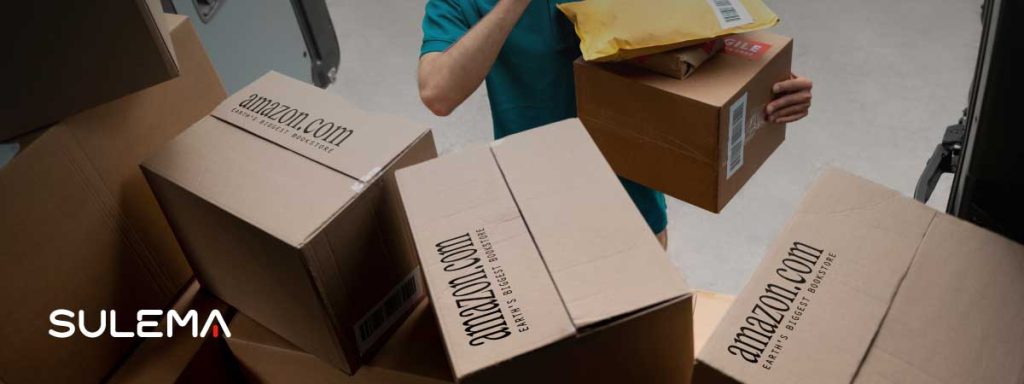 El primer cambio en 1998 Evolución de logos de marcas, caso de Amazon. Un hombre descargando paquetes de Amazon.com de un camión